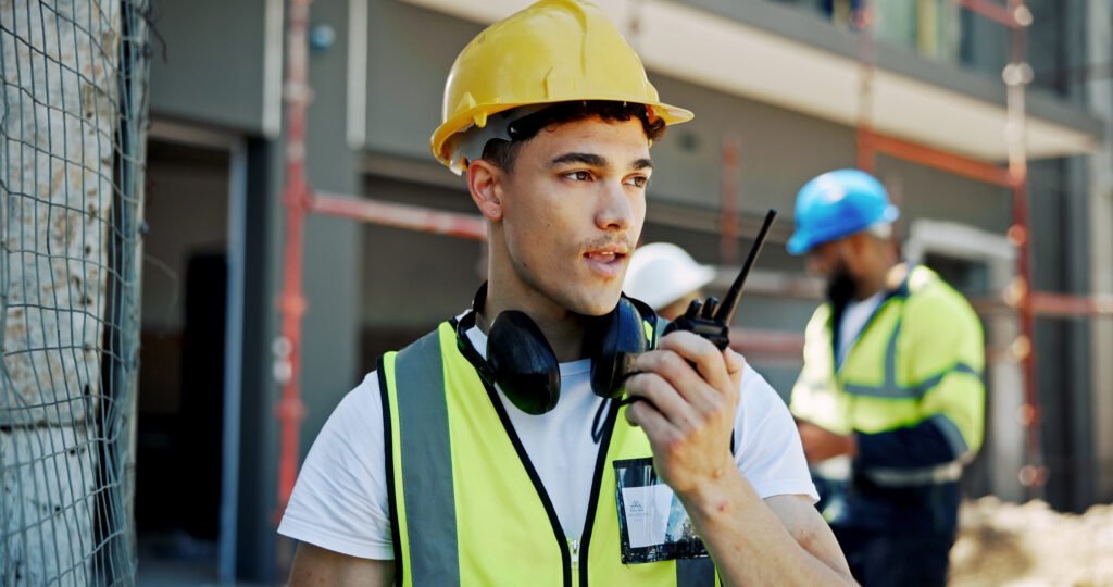 Bauarbeiter mit Funkgerät auf Baustelle.